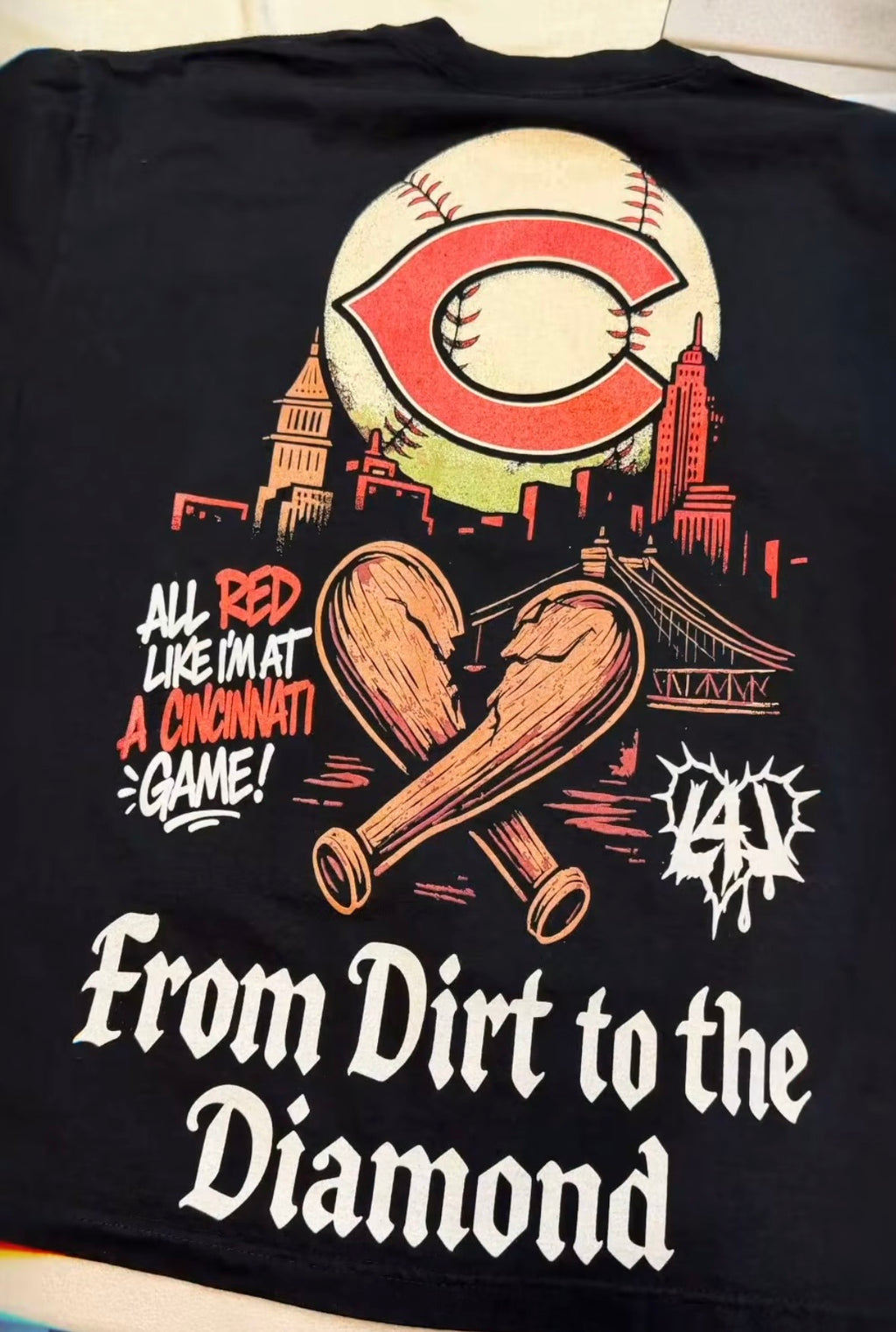Black t-shirt with baseball-themed design featuring a cityscape and text on a white background.